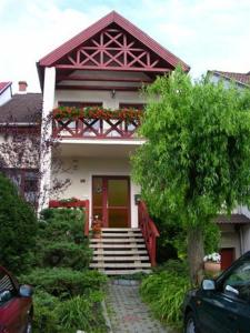 uma casa com uma porta vermelha e escadas à frente em Siesta Vendégház em Eger