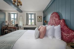 een slaapkamer met een groot wit bed met kussens bij Egypt Mill Hotel and Restaurant in Nailsworth