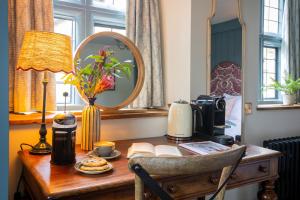 a desk with a lamp and a mirror on it at Egypt Mill Hotel and Restaurant in Nailsworth
