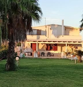 una casa con una palmera delante de ella en Villa delle Stelle con piscina, en Leverano