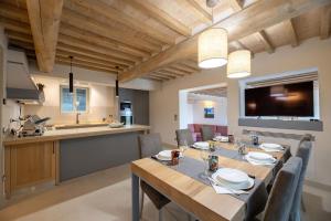 ein Esszimmer mit einem langen Tisch und einer Küche in der Unterkunft Villa Luana in Cortona