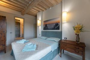 ein Schlafzimmer mit einem Bett und einem Tisch mit Handtüchern darauf in der Unterkunft Villa Luana in Cortona + 46 Fotos