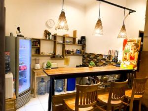 a kitchen with a bar with chairs and a refrigerator at The Koi Guest House in Canggu