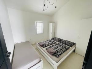 a small white room with a bed in it at Villa Melissa in Pag