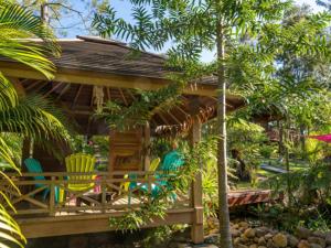 une maison avec des chaises colorées et une terrasse couverte dans l'établissement Oasis de Tendéa - Bali à Farino, à Farino