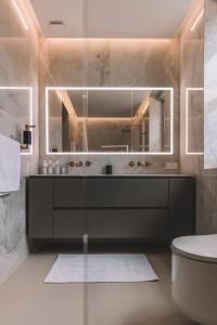 a bathroom with a mirror and a sink and a toilet at VILLA QUINTA TORRINHA Rooms in Funchal