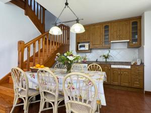 a kitchen with a table with chairs and a staircase at Casa Rio Cubas in Cubas