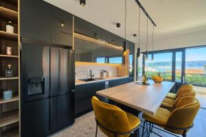 a kitchen with a wooden table and yellow chairs at Toni's Place - Sea-View & Pool in Slatine