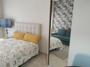 um quarto com um espelho, uma cama e um sofá em LUNA VERDE apartamento centro con parking em Oviedo