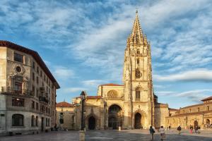 uma grande igreja com uma torre de relógio em uma cidade em LUNA VERDE apartamento centro con parking em Oviedo