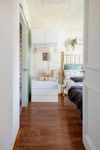- une chambre avec un lit et une commode blanche dans l'établissement Gallo House, à Cospicua