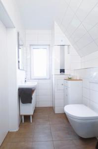 a white bathroom with a tub and a sink at Ferienhaus 88 in Bad Arolsen