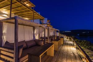une maison avec un canapé sur une terrasse la nuit dans l'établissement SALT SUITES MILOS, à Pollonia