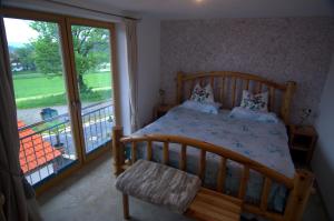 a bedroom with a wooden bed and a balcony at Bio Ferienhof Heiler in Feldkirchen-Westerham