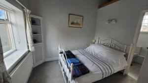 a small bedroom with a bed and a window at Ballygate Stable in Beccles