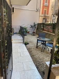 een patio met een tafel en stoelen op een binnenplaats bij Casa Roberta in Catania