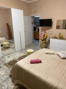 een slaapkamer met een bed met een roze handdoek erop bij Casa Roberta in Catania