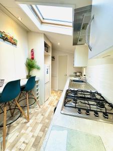 a kitchen with a stove and a table with chairs at Ocean Breeze in Filey