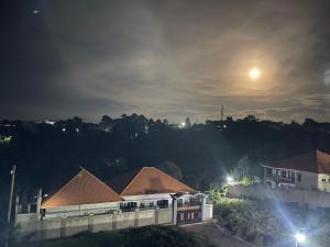 - une vue sur un bâtiment avec la lune dans le ciel dans l'établissement Serene Apartments, à Bulindo