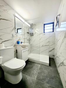 y baño con aseo, lavabo y ducha. en Florence Hotel Apartments en Ayia Napa