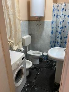 een badkamer met een wasmachine, een toilet en een wastafel bij Casa Roberta in Catania