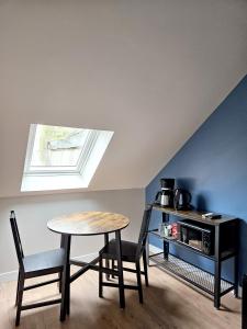 Una mesa y sillas en una habitación con ventana. en Onyx Blue, en Saint-Aignan