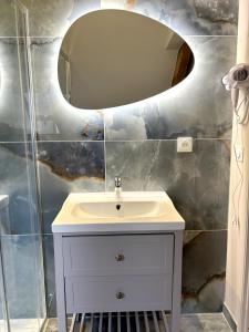 y baño con lavabo blanco y espejo. en Onyx Blue, en Saint-Aignan