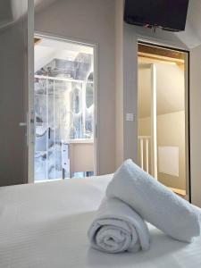 Una toalla blanca encima de una cama. en Onyx Blue, en Saint-Aignan