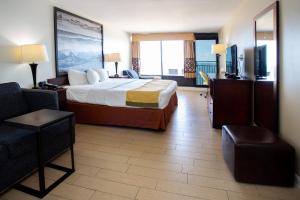um quarto de hotel com uma cama e uma varanda em Aqua Vista Resort Hotel em Virginia Beach