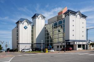 a large building with two towers with a parking lot at Aqua Vista Resort Hotel in Virginia Beach