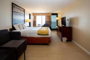 um quarto de hotel com uma cama e um sofá em Aqua Vista Resort Hotel em Virginia Beach
