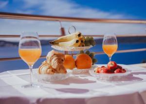 een tafel met twee glazen wijn en een bord eten bij Lovely 1-bedroom APT w/ seaview + free parking in Trogir