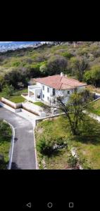 a white house with a red roof and a road at Luxury Seaview Apartment with private pool in Kostrena