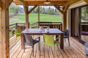 una terraza de madera con mesa y sillas. en La Ferme Francej Luxury Farmhouse Bohinj, en Bohinjska Bistrica