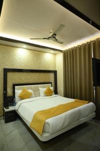 een slaapkamer met een groot wit bed met gele kussens bij Kings Inn Hotel in Rānchī
