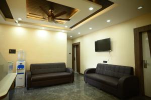 een wachtkamer met 2 leren banken en een flatscreen-tv bij Kings Inn Hotel in Rānchī