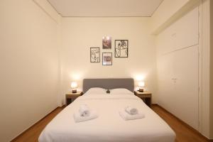 a bedroom with a large white bed with two lamps at Cozy 3 Bedroom Retreat next to Kolonaki - Greecing in Athens