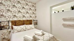 a bedroom with a bed with towels on it at SIBS Sanlúcar Guadalquivir 2 Coqueto Ideal Parejas in Sanlúcar de Barrameda