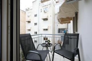 a balcony with chairs and a table and a building at Cozy 3 Bedroom Retreat next to Kolonaki - Greecing in Athens