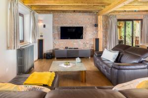 a living room with a couch and a tv at La Ferme Francej Luxury Farmhouse Bohinj in Bohinjska Bistrica