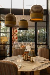 a dining room with a table with chairs and pendant lights at Vmaison Brera Milano in Milan