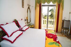 een slaapkamer met een groot wit bed en een raam bij FabHotel Prime Indeedcare Resort Bakkhali in Bakkhali