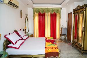 een slaapkamer met een bed met rode en gele gordijnen bij FabHotel Prime Indeedcare Resort Bakkhali in Bakkhali