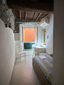 a bedroom with a bed and a table and a window at Locanda Ca Dei Duxi in Riomaggiore