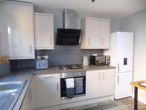 a kitchen with white cabinets and a stove top oven at Modern 3 Bed - Lincoln - Parking in Lincoln