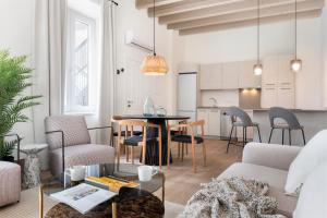 een woonkamer met een tafel en stoelen en een keuken bij Magno Apartments Almansa in Sevilla
