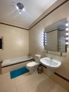 a bathroom with a toilet and a sink and a tub at Sliema 2bed with Backyard in Sliema