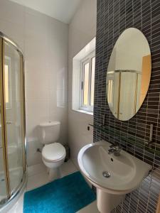a bathroom with a sink and a toilet and a mirror at Sliema 2bed with Backyard in Sliema