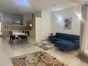 a living room with a blue couch and a table at Sliema 2bed with Backyard in Sliema