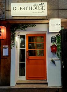 a front door of a guest house with a red door at Space ARA in Seoul